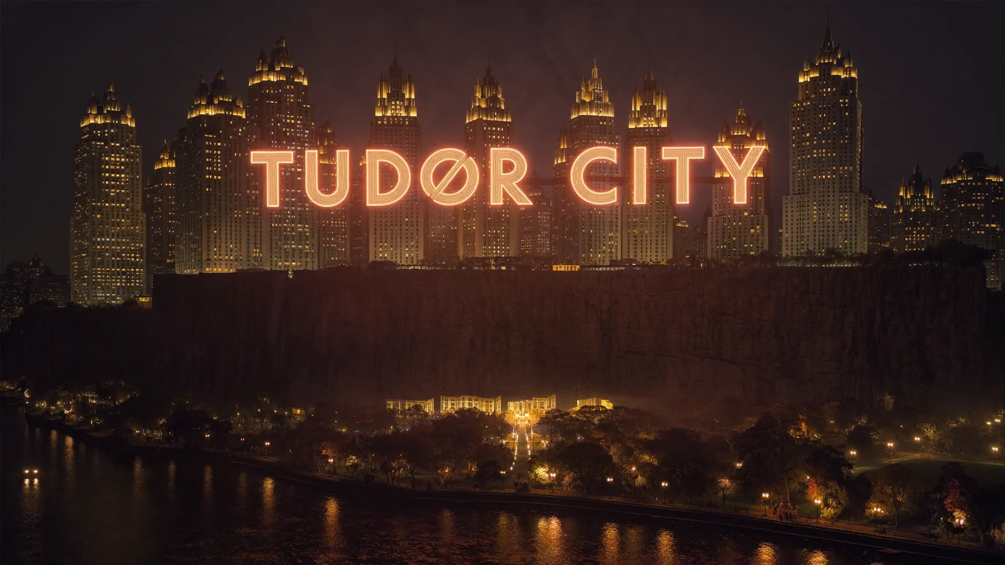 The neon TUDOR CITY sign glowing over the East River at night